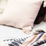 Boho decorative pillows in assorted textures arranged on a gray couch