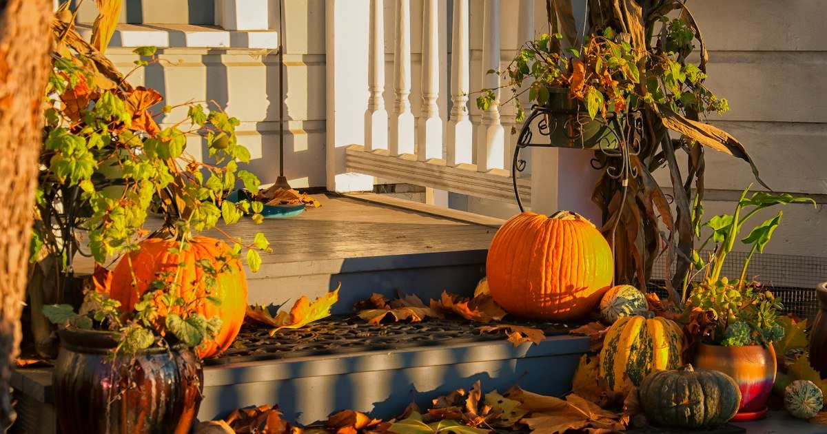Fall door decor with orange pumpkins arranged on a home doorway