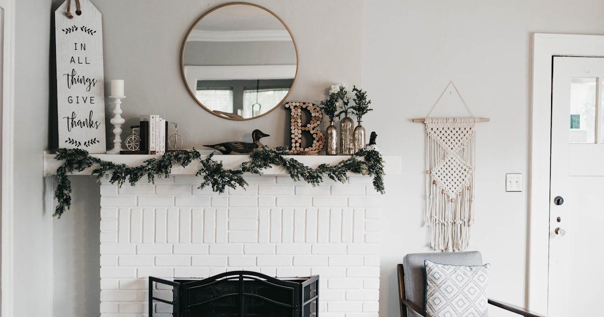 Fall mantel decorating ideas on a white fireplace mantel with layered decor and warm accents