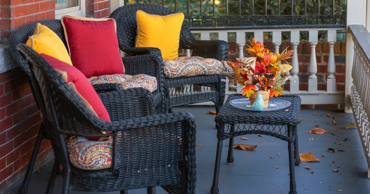 Wicker chairs styled with cushions and throws for a fall seating area
