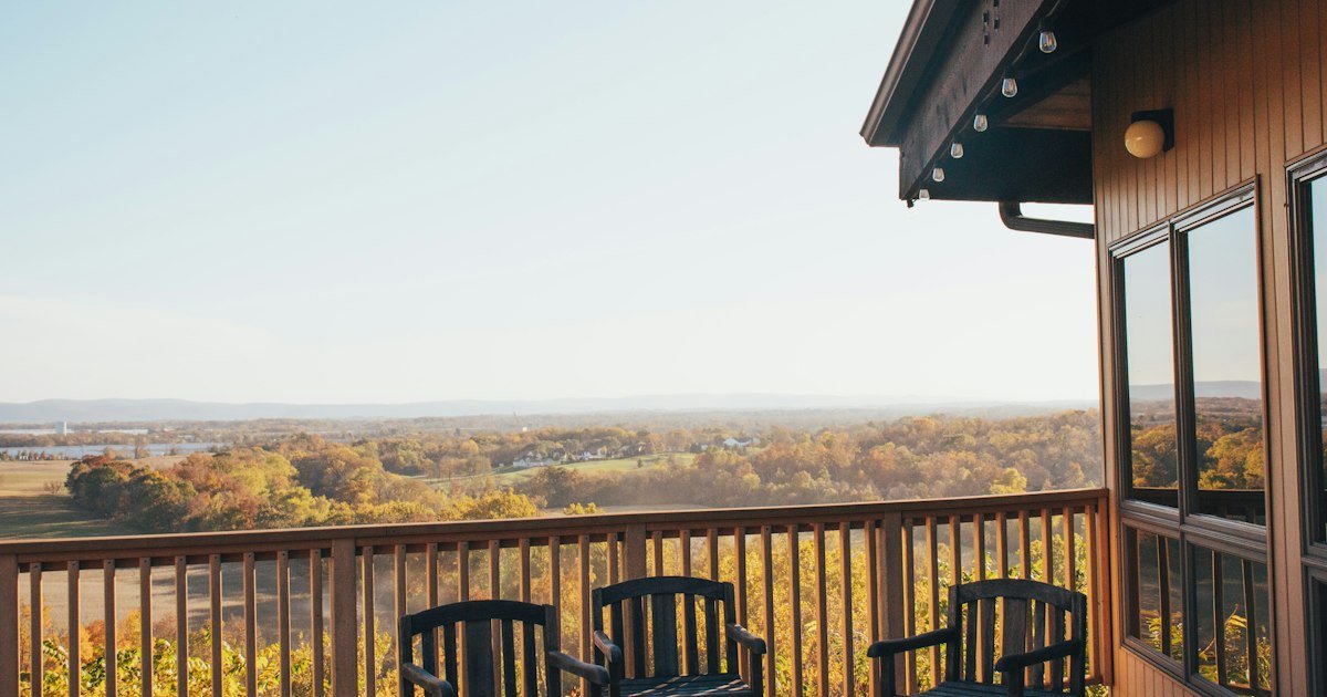 Deck seating styled for fall, chairs facing a wooded view
