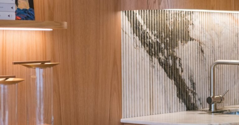 Japandi kitchen with wood cabinets and a marble backsplash in a calm neutral palette