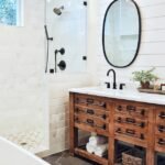 Rustic bathroom decor with a white ceramic bathtub near a brown wooden vanity cabinet