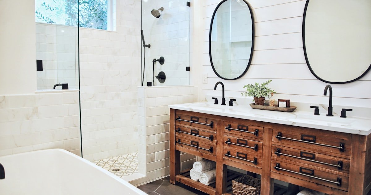 Rustic bathroom decor with a white ceramic bathtub near a brown wooden vanity cabinet