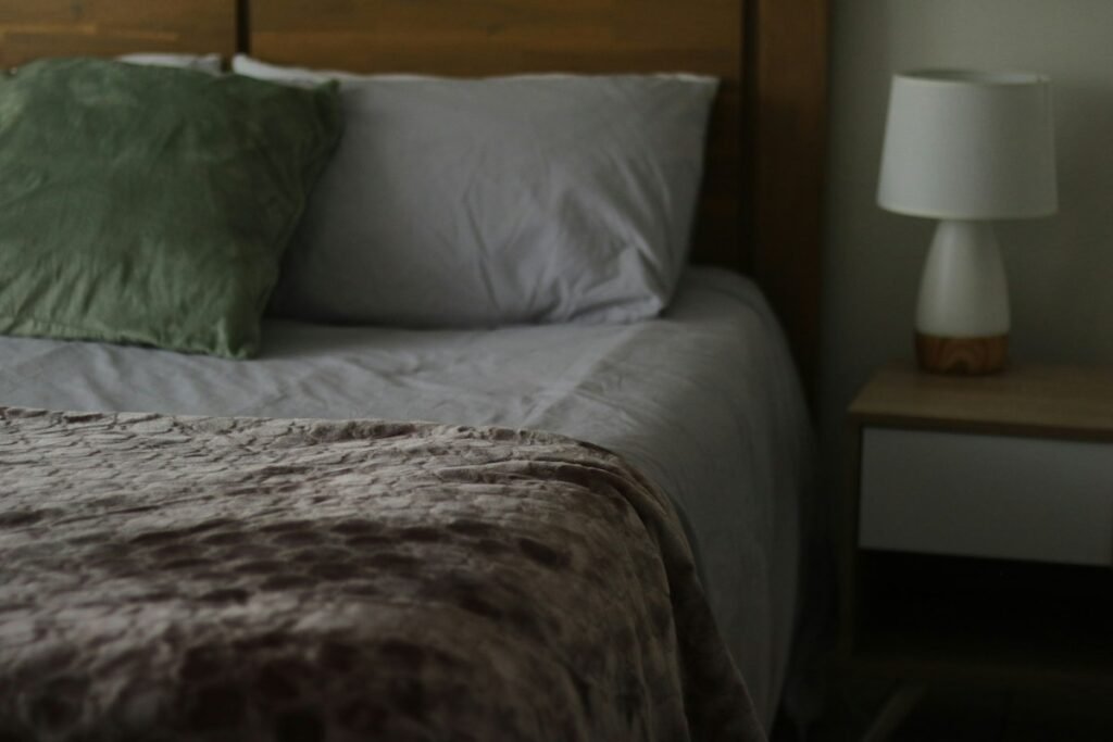 Bed with a wooden headboard and a bedside lamp