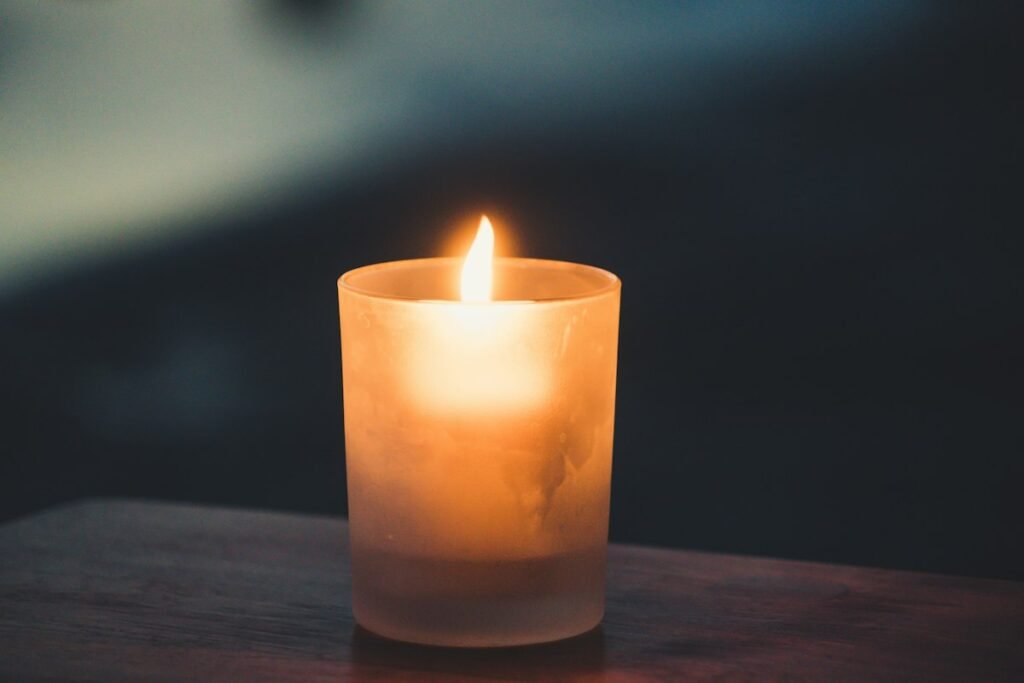 Lit tea light on a brown surface