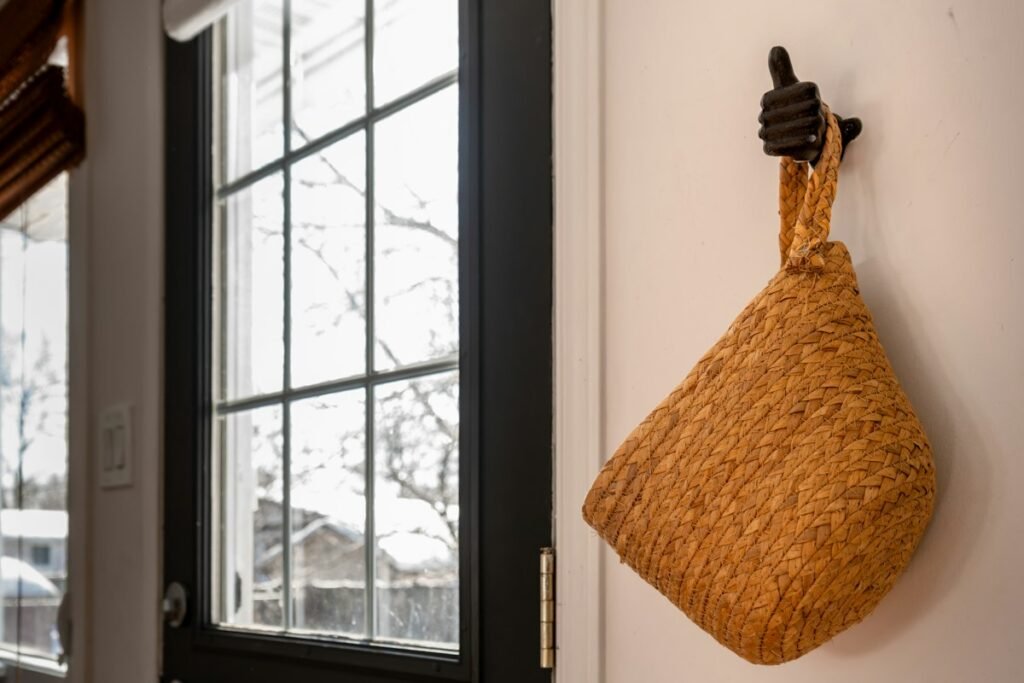 Woven basket hanging on a wall by a window