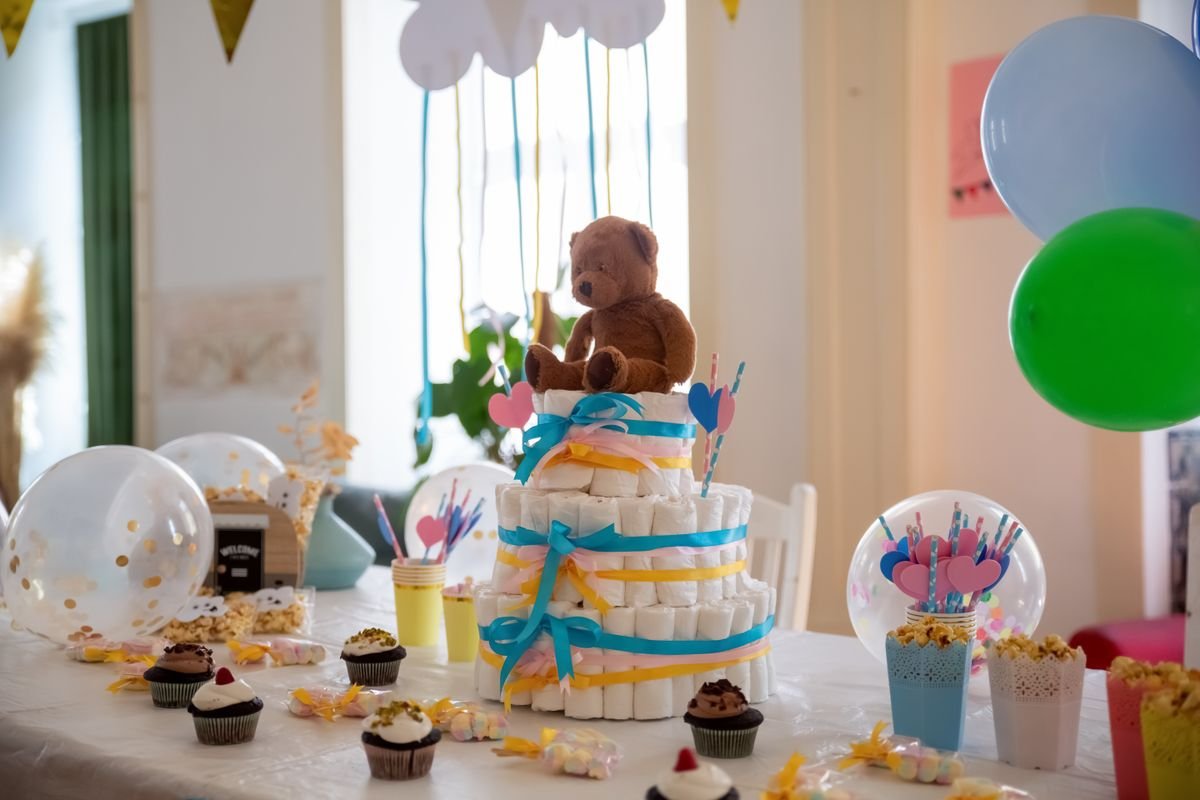 Dessert table with pastel cupcakes and a diaper cake centerpiece