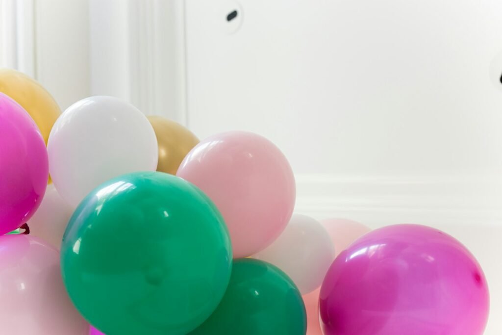Purple and pink balloons against a white wall