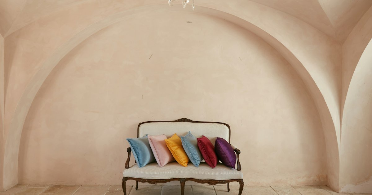 Blue and red boho decorative pillows layered on a black armchair