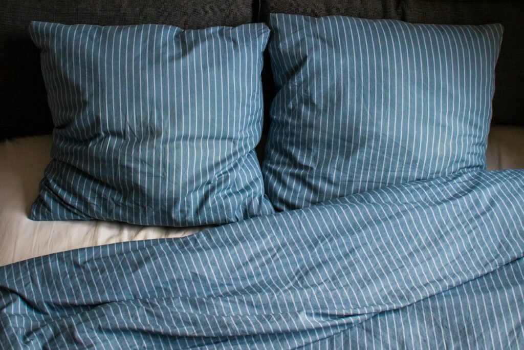 Bed with two pillows and a blanket on top