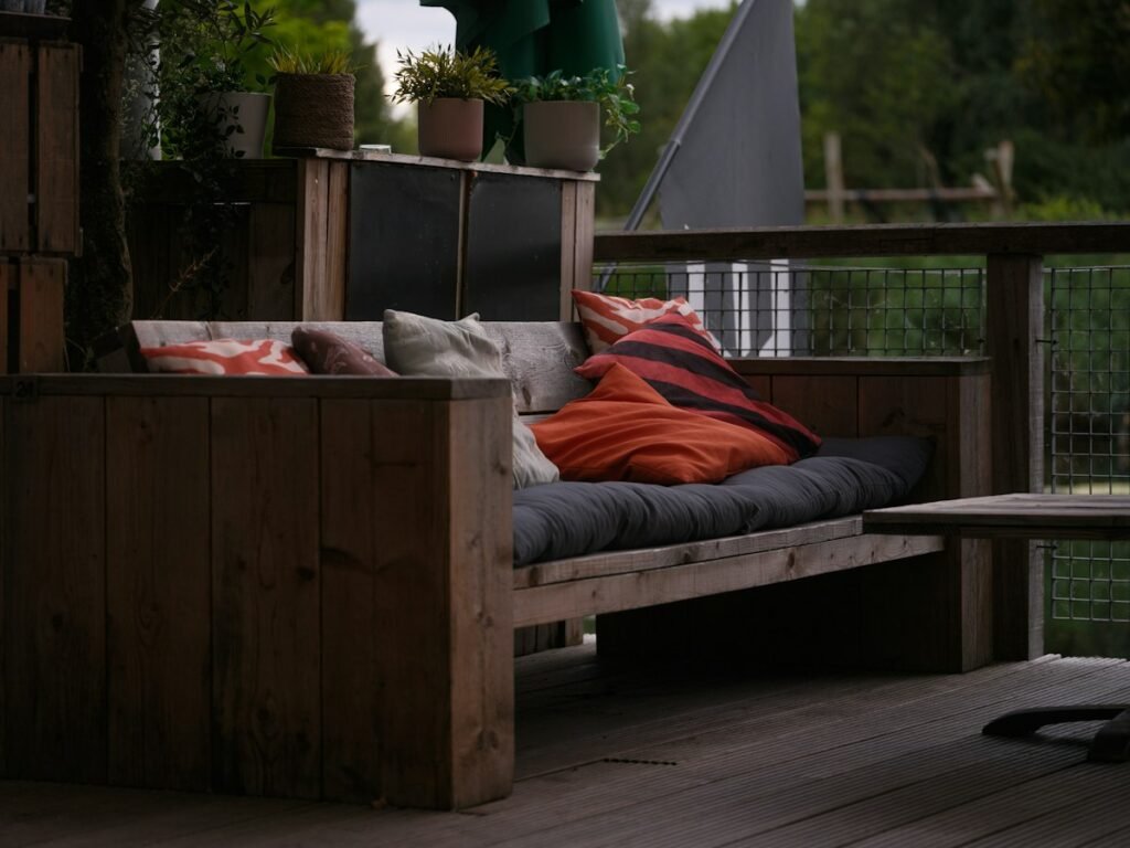 Wooden outdoor sofa with colorful cushions on a deck