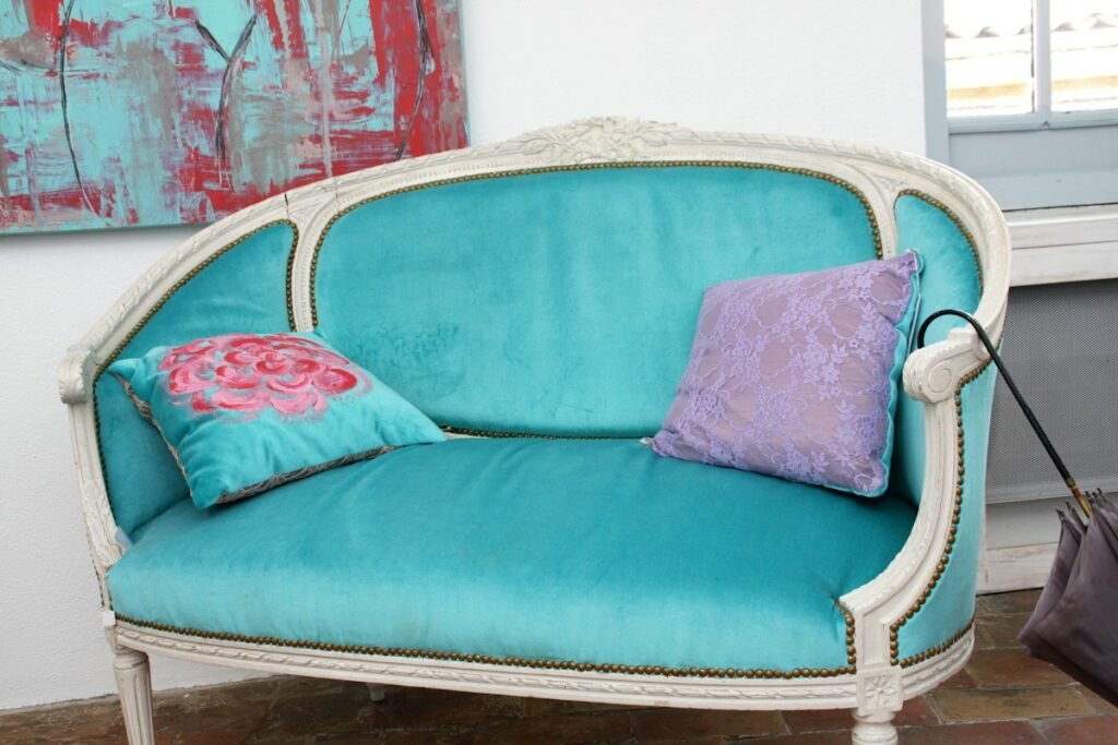 Vintage teal sofa with decorative pillows