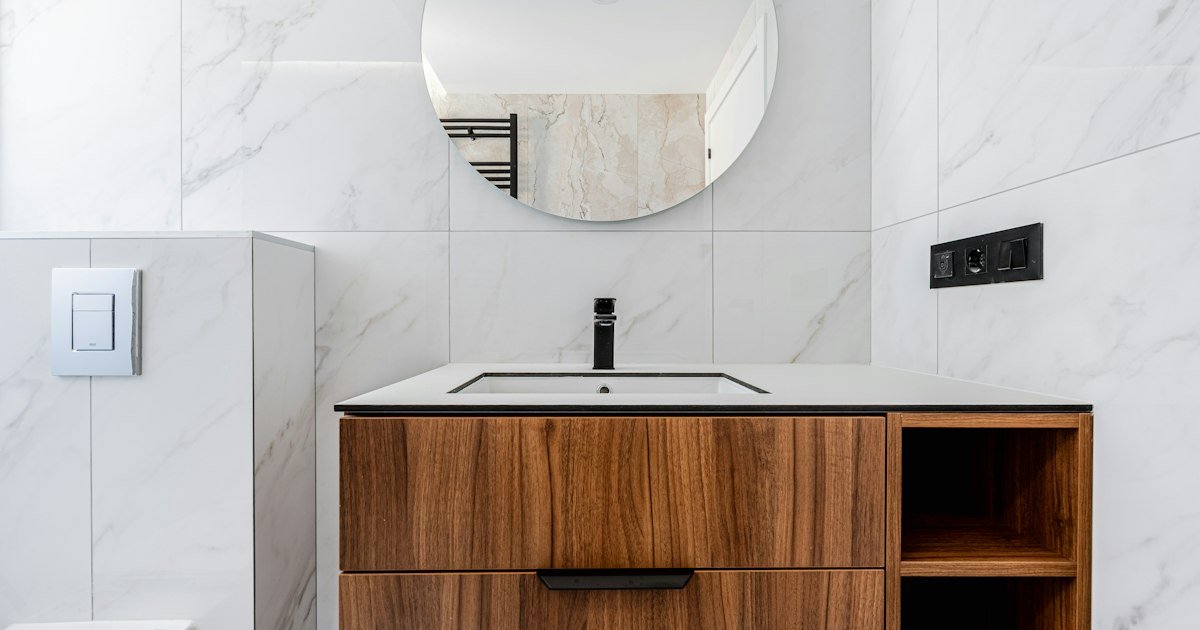 Marble tile behind a wooden vanity