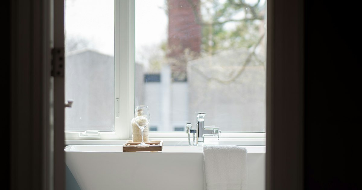 Freestanding tub near large windows