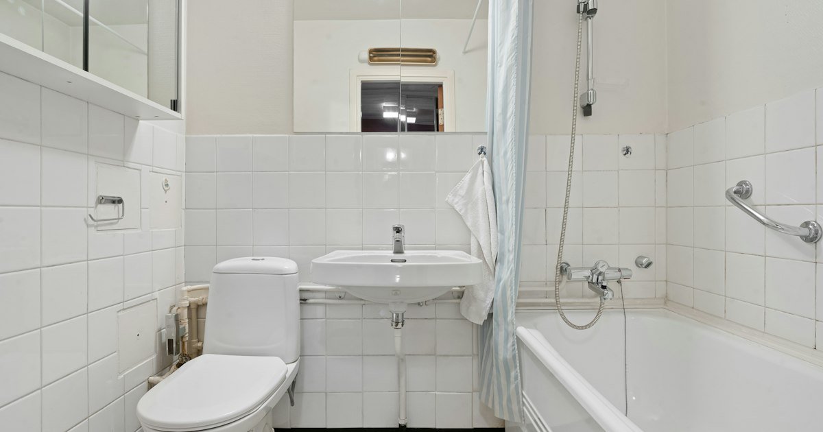 Small bathroom with a white tub, toilet and sink