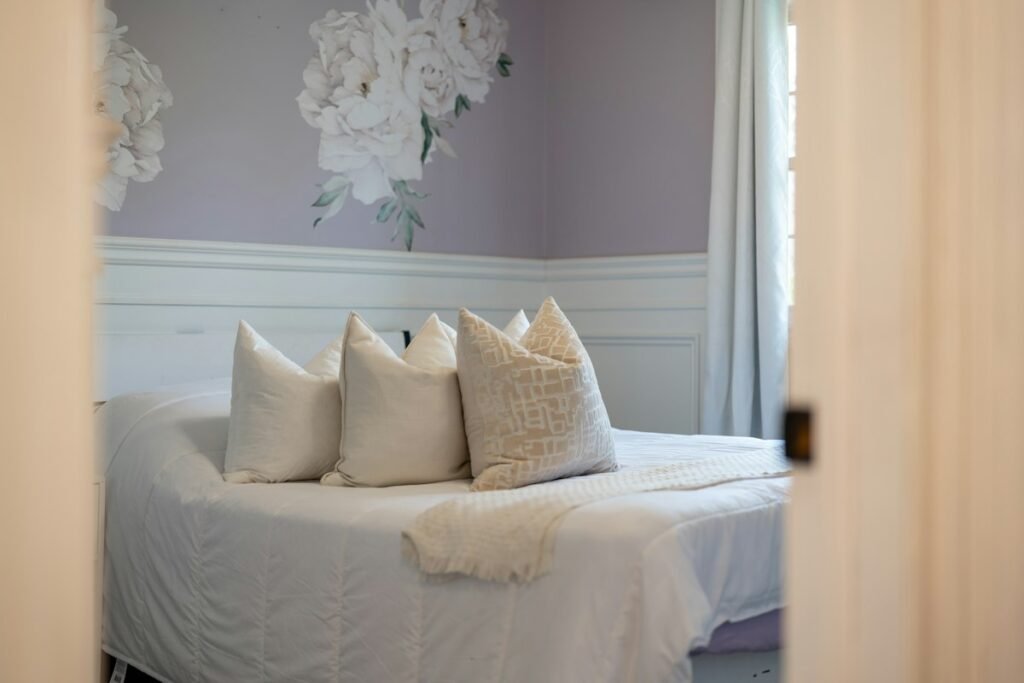 Bed with white pillows against floral wallpaper