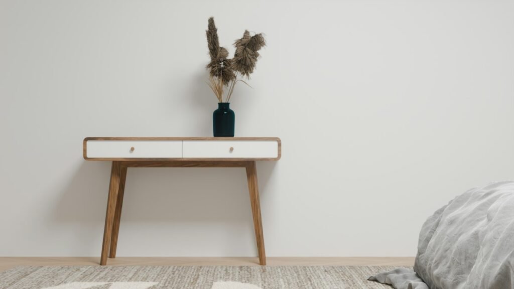 Wooden console table with white drawers and a dark vase