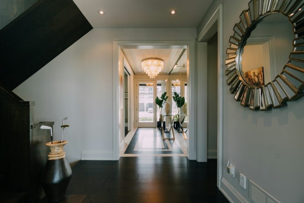 Hallway with a large mirror and a chandelier