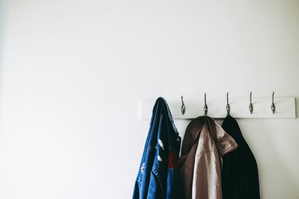 Three jackets hanging on wall hooks
