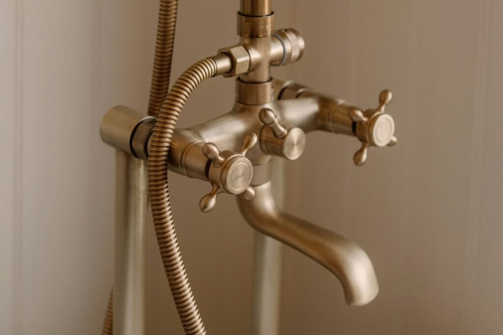 Antique brass bathtub faucet with a handheld shower head
