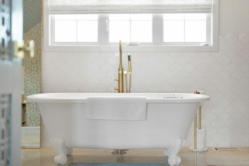 White clawfoot bathtub with gold fixtures
