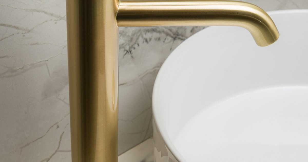 Gold faucet beside a white vessel sink