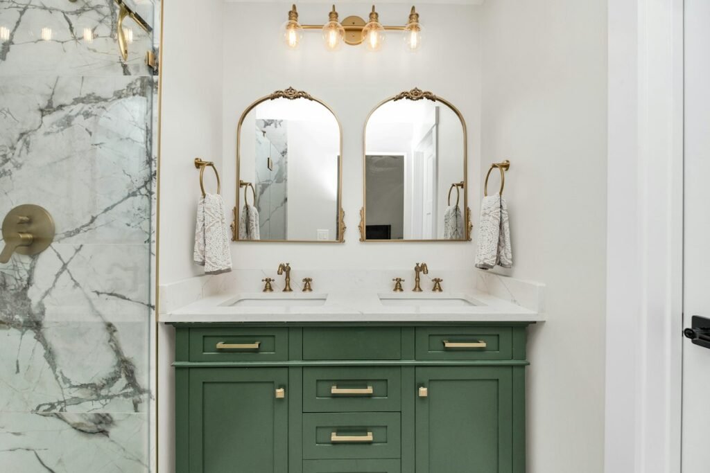 Bathroom with marble countertops and green cabinets
