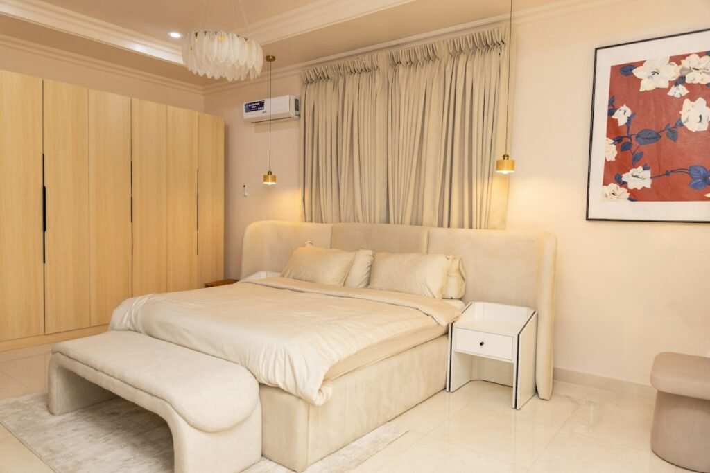 Bedroom with a large bed, a bench and neutral decor