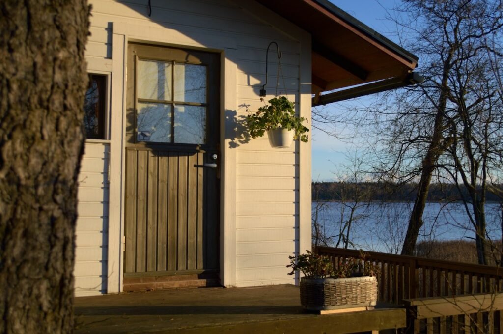 Small cabin with a porch overlooking a lake