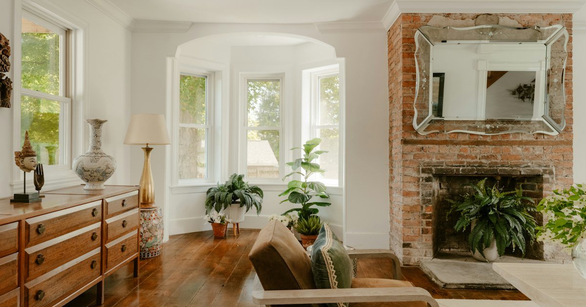Living room with a warm fireplace and a bay window