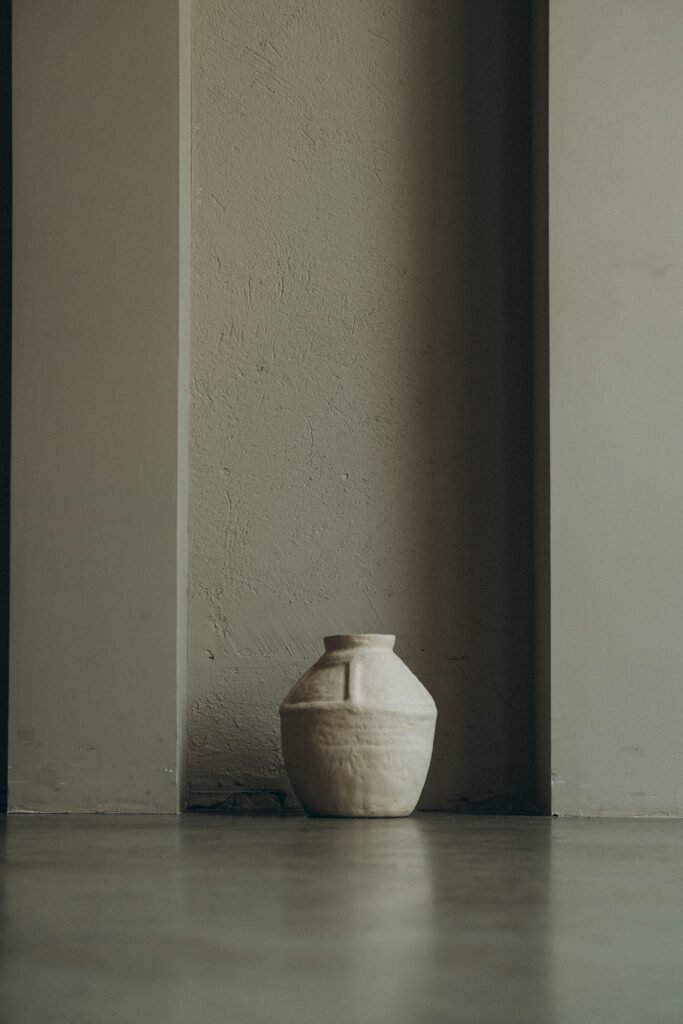 White textured vase on a gray concrete floor, the finish a bubble wrap and joint compound vase imitates