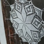 DIY doily wall decor: a handmade lace doily hung on a rustic wooden door