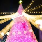 Pink Christmas decor on a softly lit tree with warm white lights