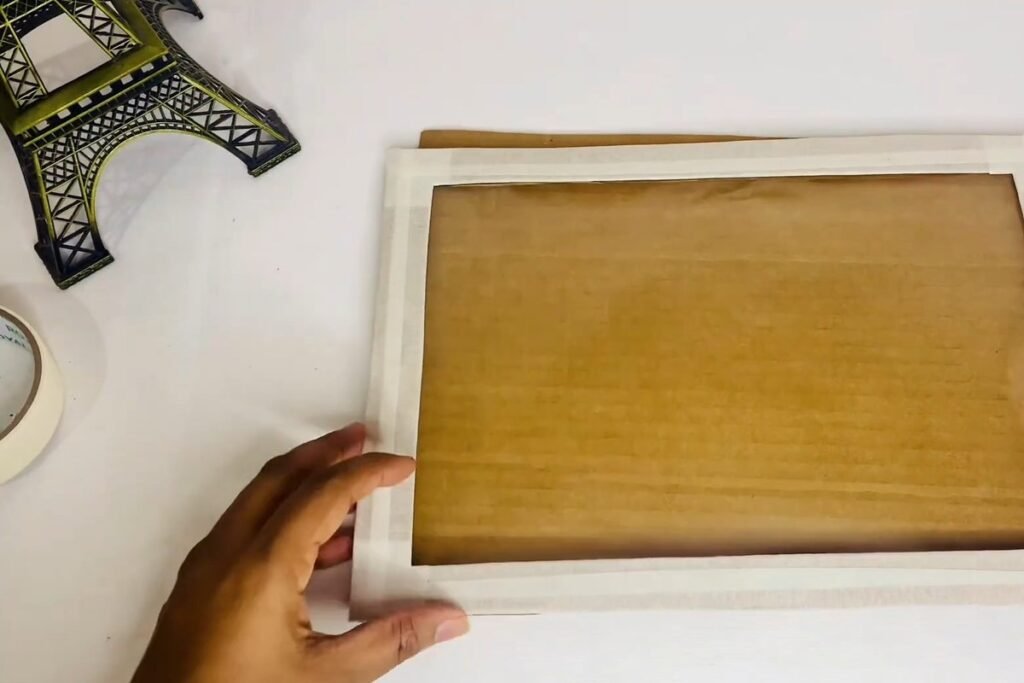 A taped frame with a brown cardboard back sheet showing through the clear plastic