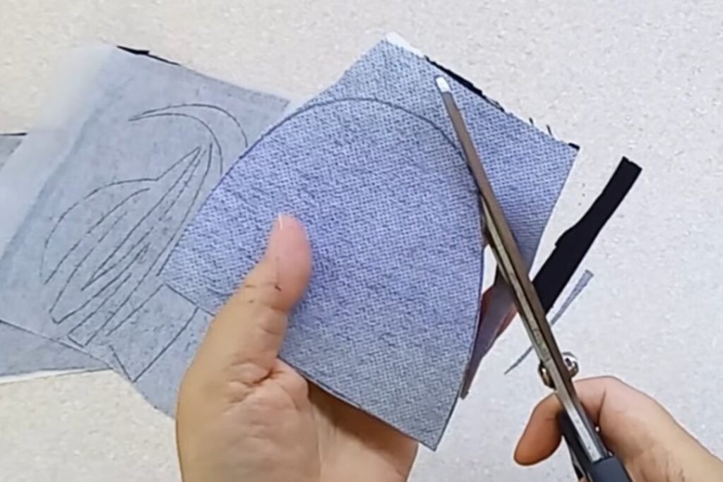 Scissors cutting along a traced line on grey interfaced fabric