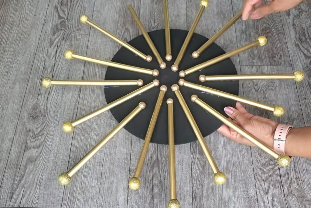 Dollar Tree wall decor finished: a black wooden circle with gold straw rays and gold glitter balls on every ray