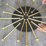 Dollar Tree wall decor finished: a black wooden circle with gold straw rays and gold glitter balls on every ray