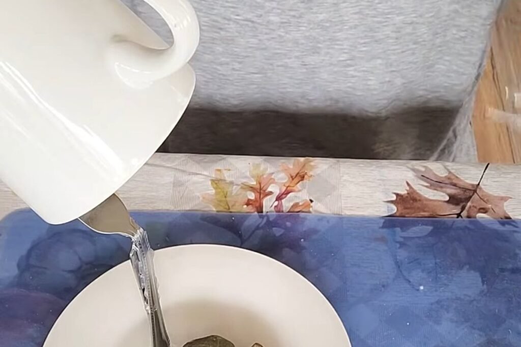 A metal fork rising from a saucer into the side of a white cup