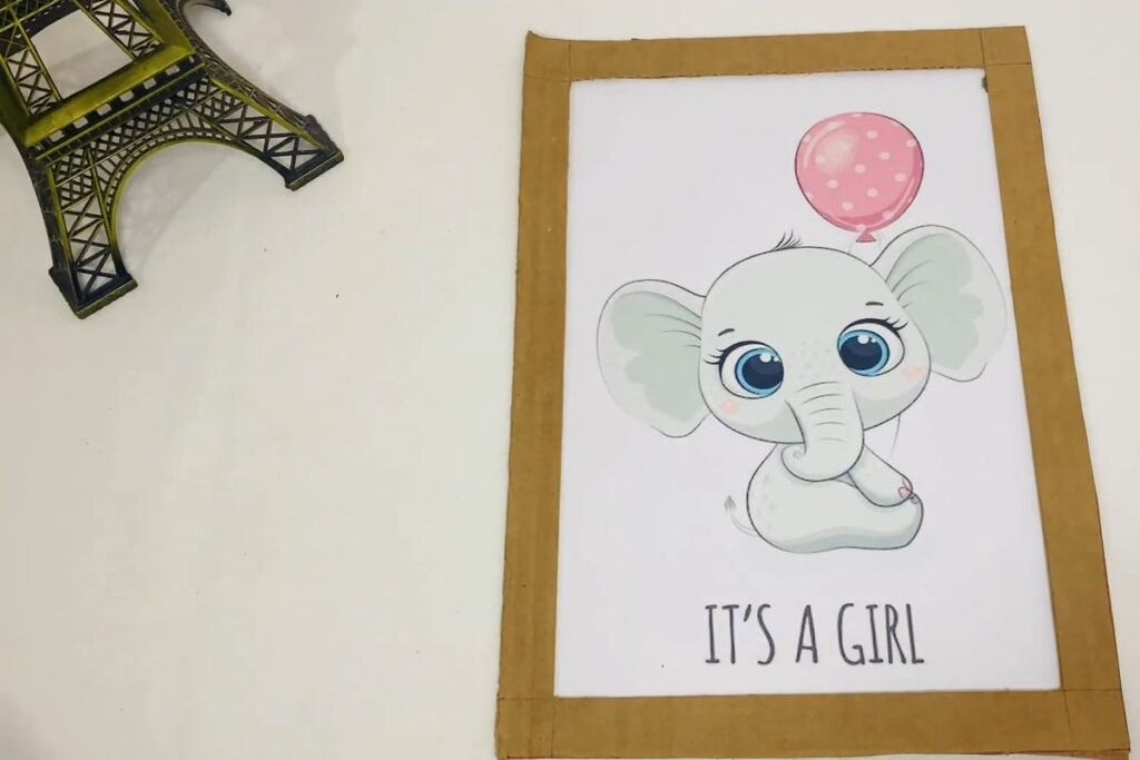A cardboard frame ring laid over a printed picture of an elephant with a balloon