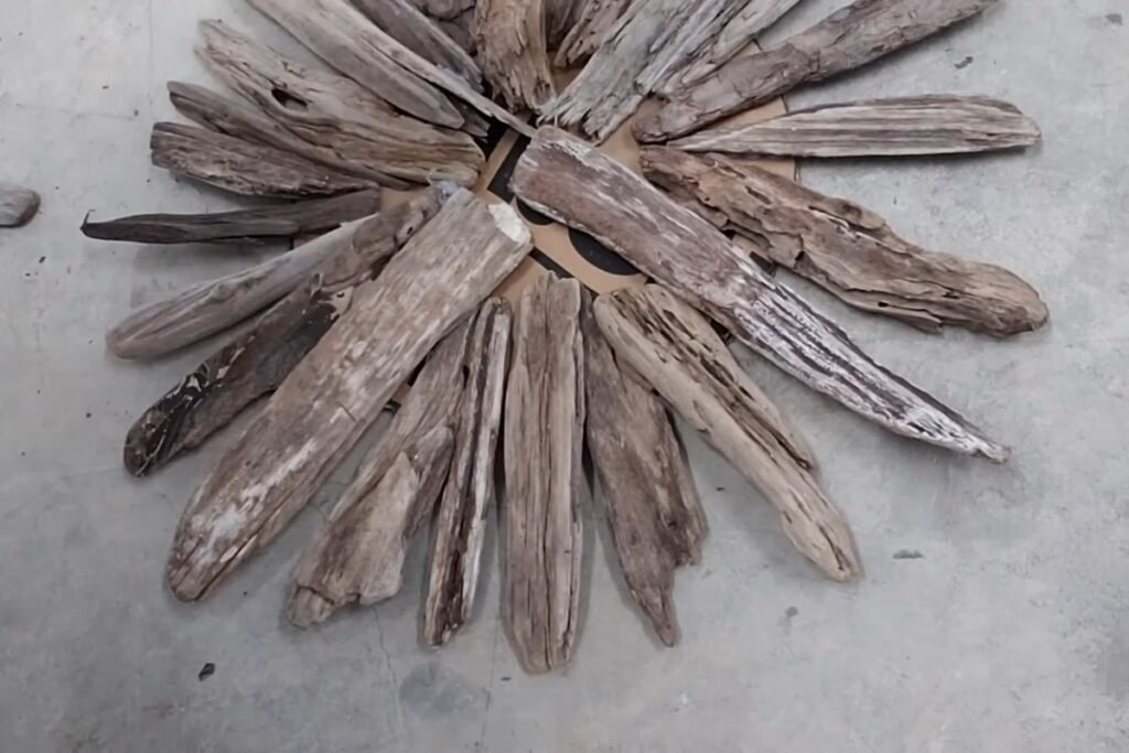 First layer of a driftwood starburst with cardboard still visible between the arms