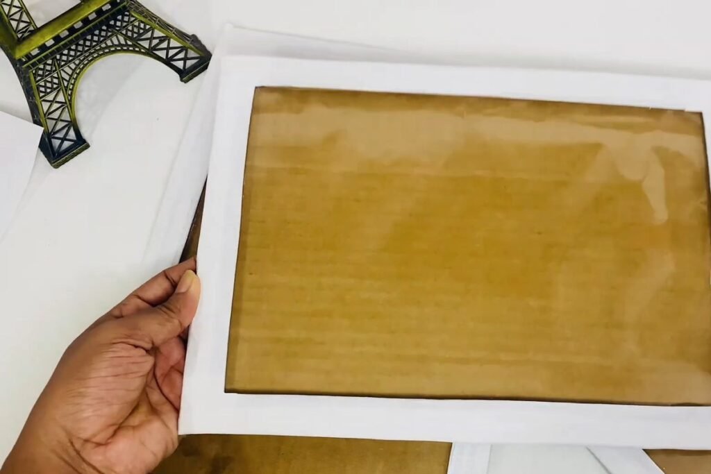 A white-painted frame with a brown back sheet visible through the plastic window