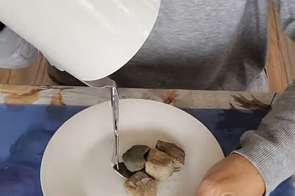 A white cup tipped sideways above a saucer with a fork and pebbles
