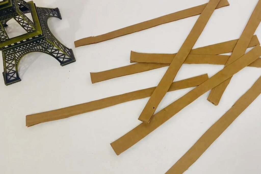 Narrow strips of brown cardboard scattered on a white table