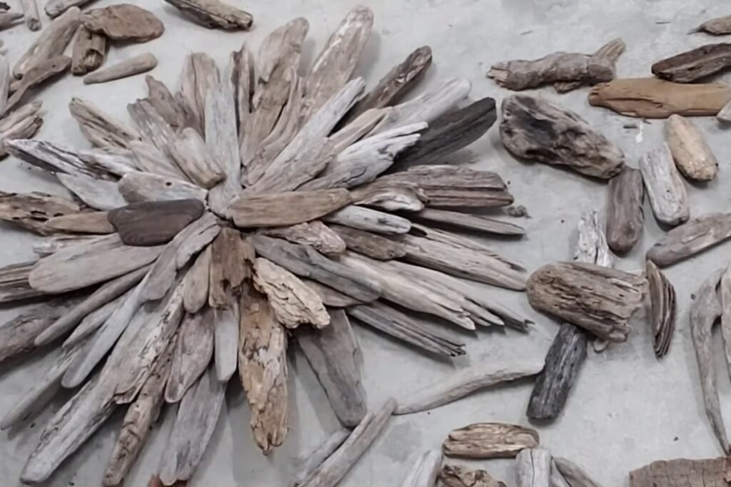 Third layer of shorter driftwood pieces on a starburst with spare pieces around it