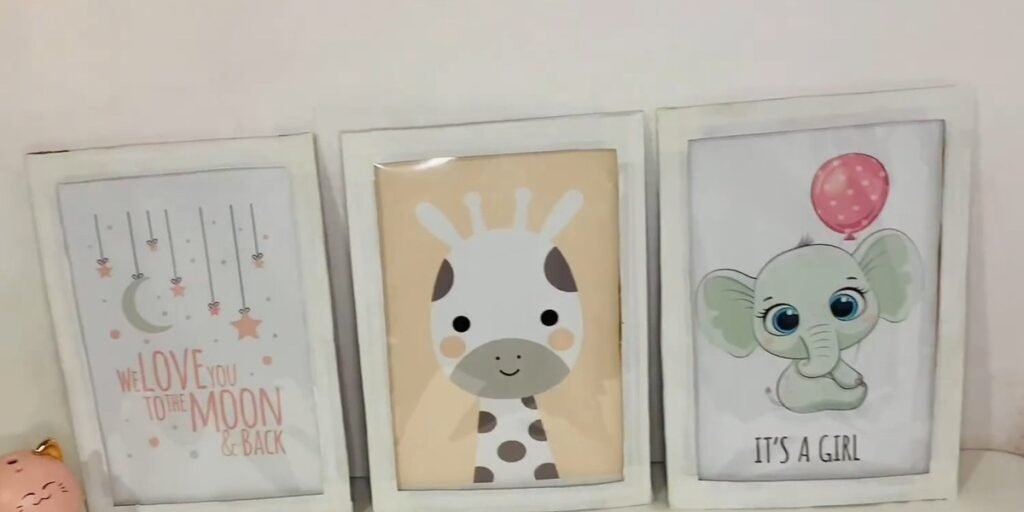 Three white DIY cardboard picture frames for nursery room wall decor, each holding a printed baby animal picture